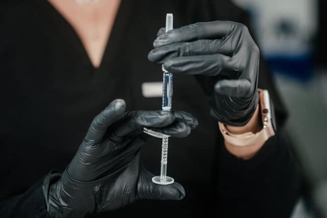 Dr. Lauren preparing her syringe with facial fillers to inject her patients.