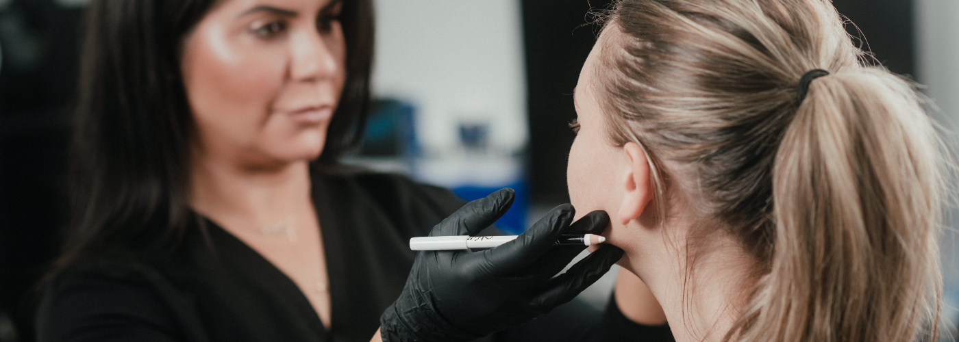 Dr. Lauren assessing where to add fillers to the face of one of her patients.