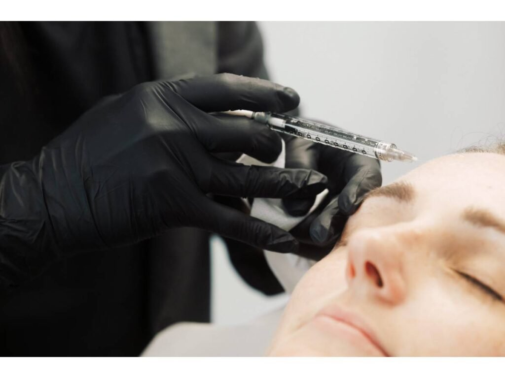 Dr. Lauren injecting anti-wrinkle filler in her patient's eyebrow area.