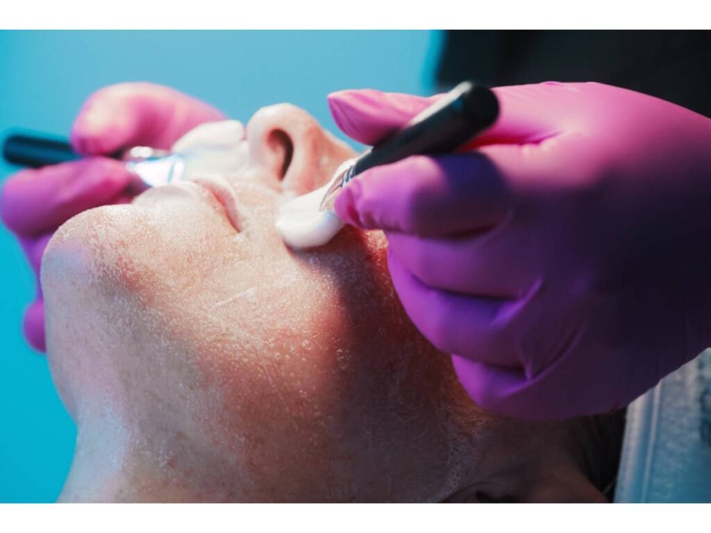 One of our Skin Suite team cleansing a patient's face to prep her for Hydrafacial.