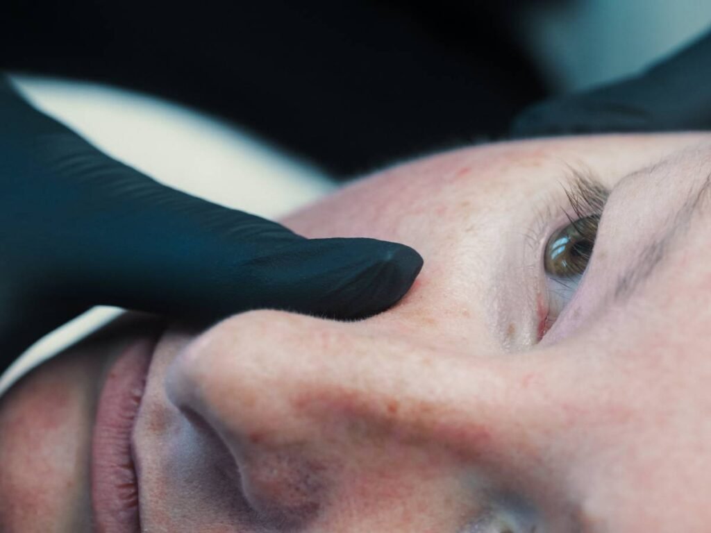 Dr. Lauren assessing a patient's face for sun spots.