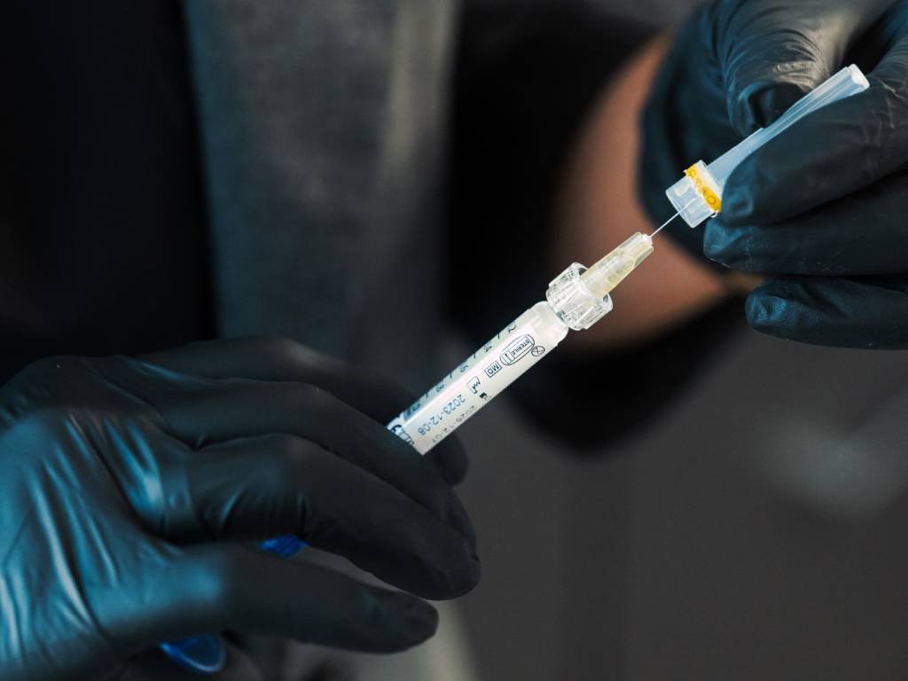 Dr. Lauren prepping a syringe with polynucleotides to be used on her patient's face.
