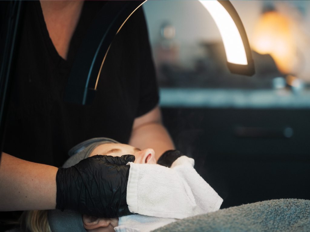 Skin Therapist Lynn prepping a patient's face for a treatment.
