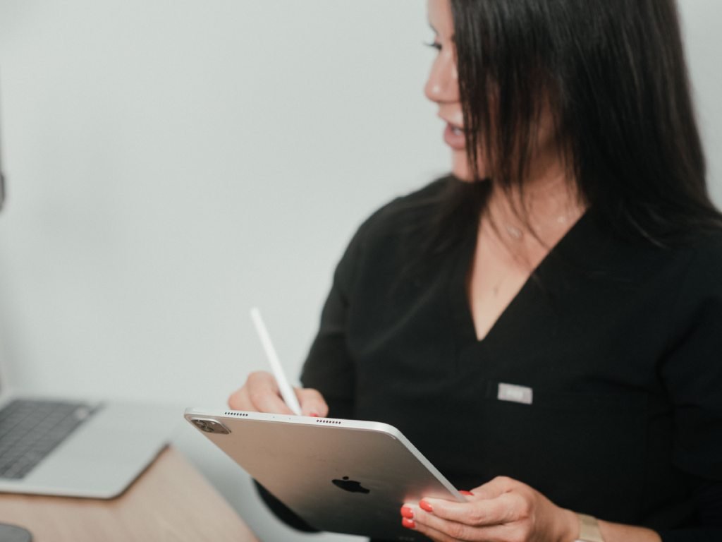 Dr. Lauren taking notes on her iPad during consultation with a patient.