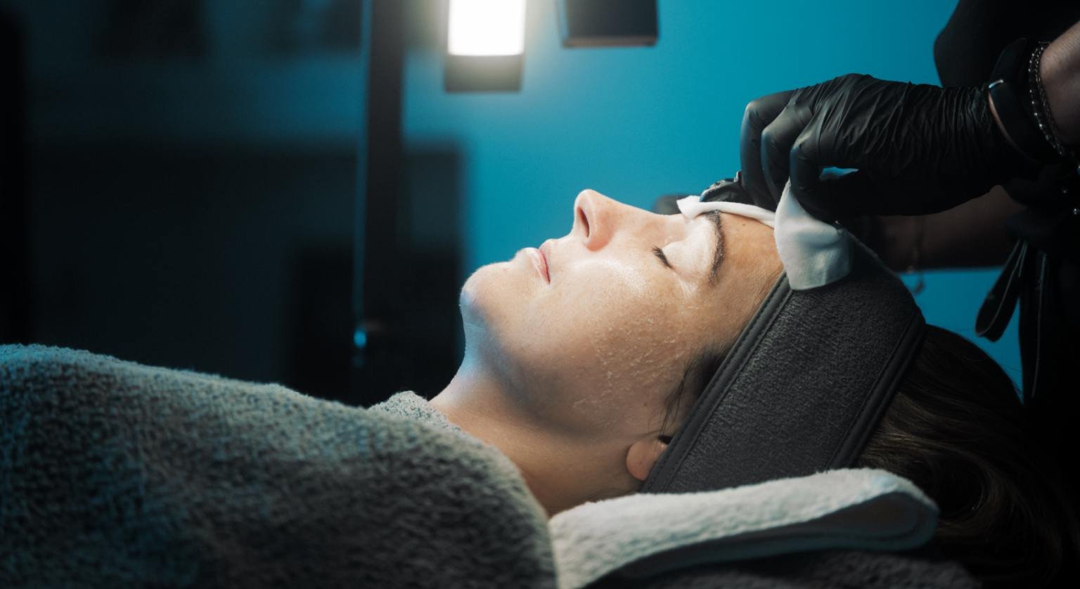 Skin Therapist Lynn prepping a patient's face for microneedling treatment.