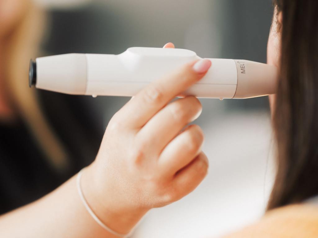 Skin Therapist Steph using a skin-analysing tool to assess a patient's skin.