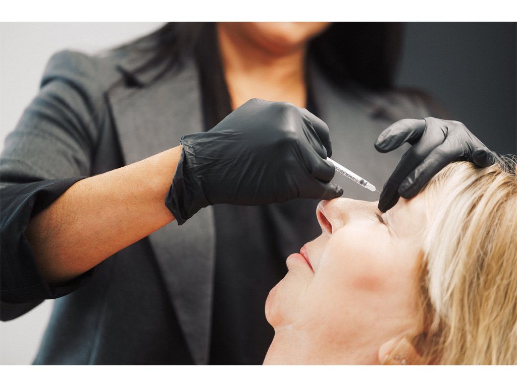 Dr. Lauren injecting a patient's forehead during a medical aesthetic treatment.