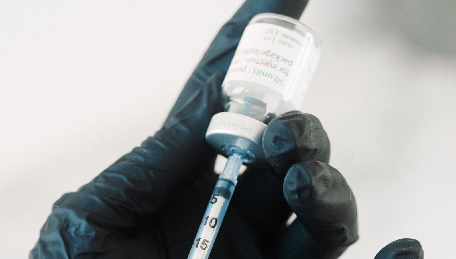 Dr Lauren taking out medical-grade skin treatment from a syringe to treat a patient.