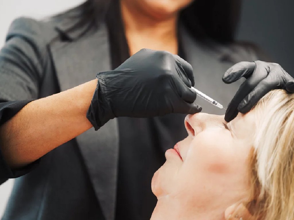 Dr. Lauren injecting a patient's forehead during a medical aesthetic treatment.