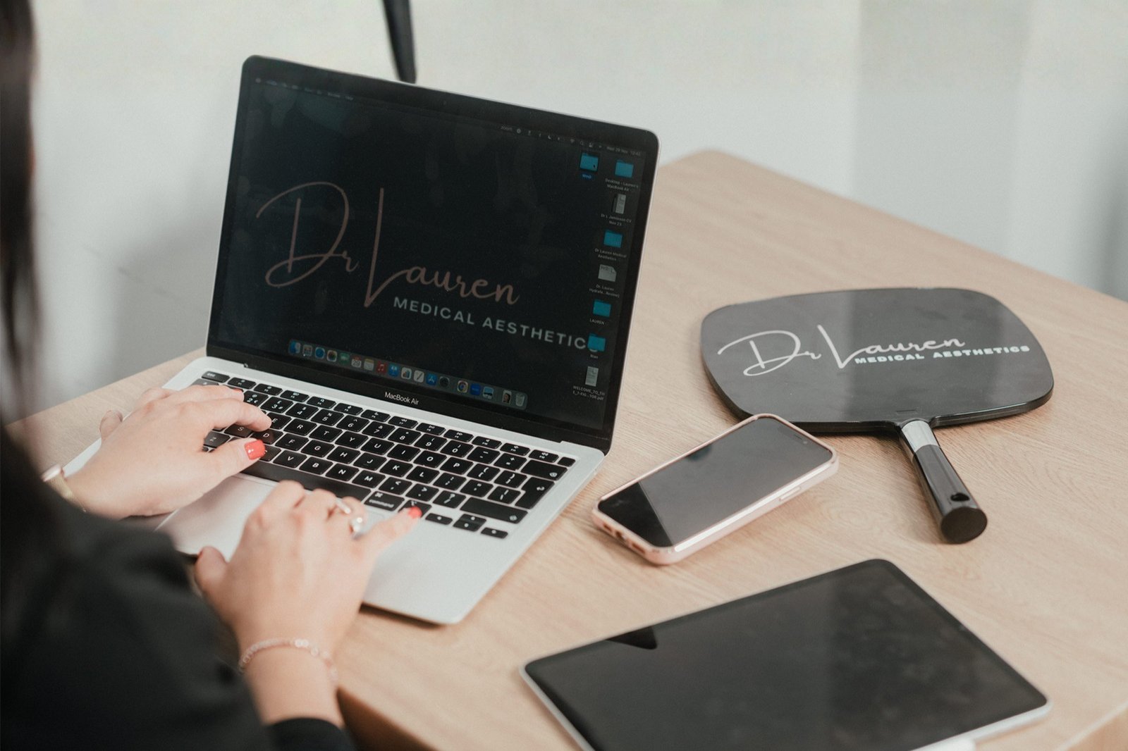 Dr Lauren using her laptop to stay updated on the new Scottish aesthetic regulations.