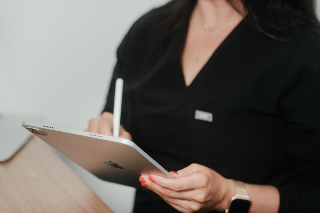 Dr Lauren taking notes on her iPad on how to guide a patient about which treatment would be the most suitable for her.