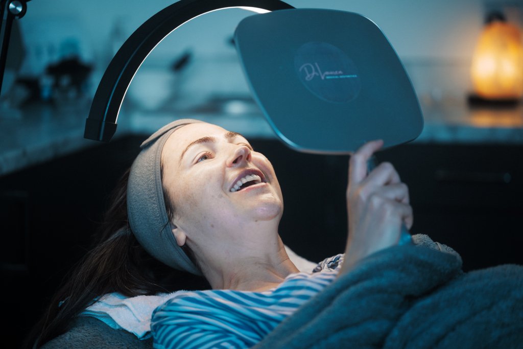 A patient seeing her face in a mirror after Hydrafacial treatment.