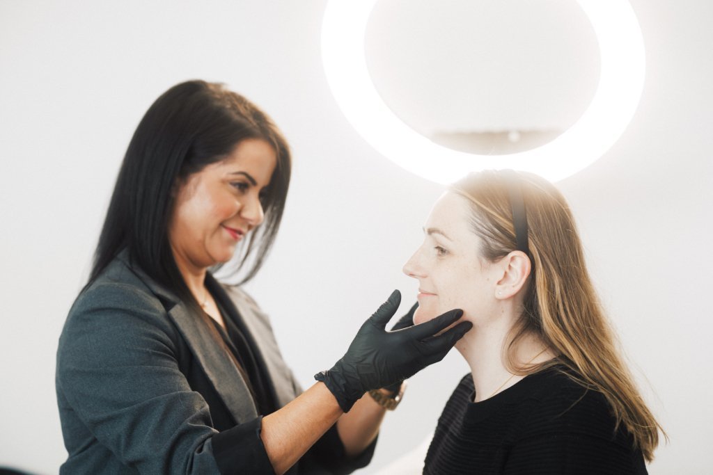 Dr Lauren assessing a patient's face to make a customised treatment plan for her.