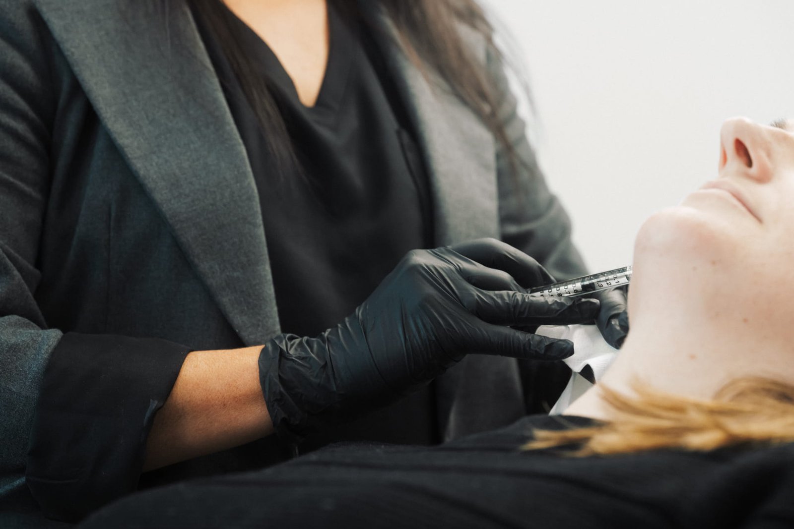 Dr Lauren injecting a facial filler in a patient's jaw area.
