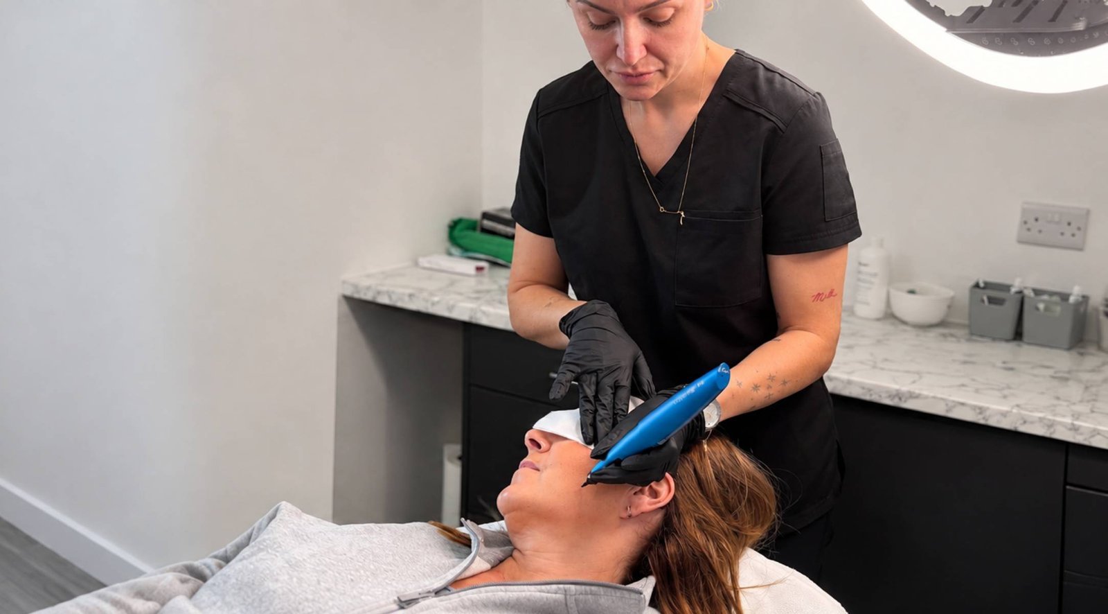 A Skin Therapist at Dr Lauren's clinic assessing and telling a patient about checking for moles.