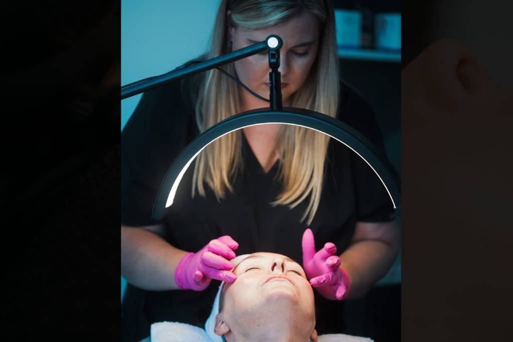A Skin Therapist at Dr Lauren's clinic prepping a patient's face for an aesthetic treatment.