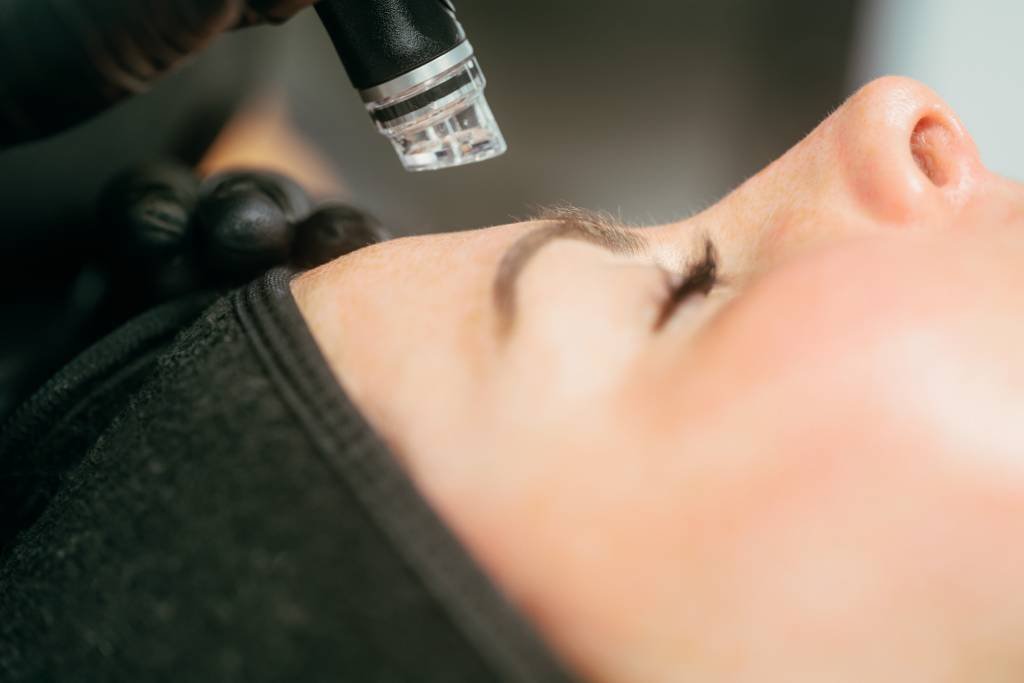 A Skin Therapist at Dr Lauren’s clinic performing a Hydrafacial treatment on a patient.